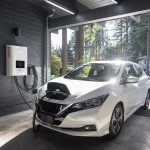 white car inside garage connected to electric charger