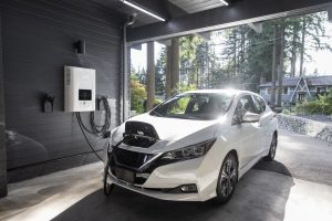 white car inside garage connected to electric charger